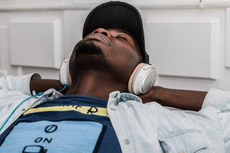 Man wearing a baseball cap listening to music with headphones