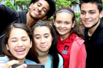 Kids posing for a picture, smiling and having a good time.