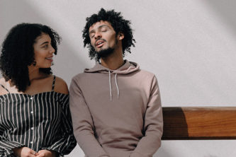 black man and woman sit on bench chatting