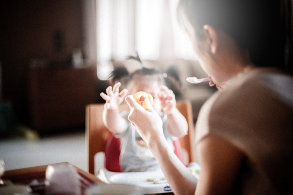 mother feed baby while holding rubber duck